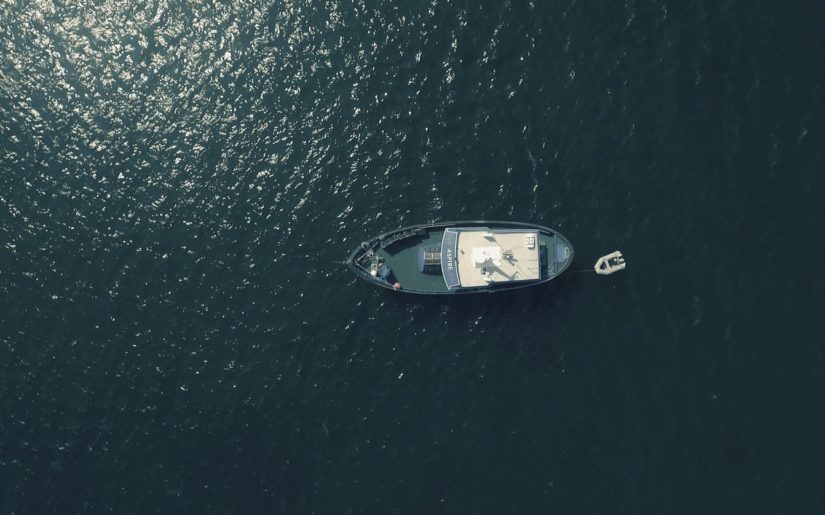Aerial view of a large boat towing a ribber dingy.