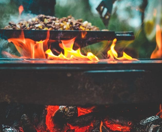 Cooking on a skillet over a campfire.